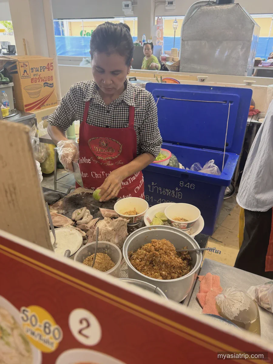 A vendor preparing food at a Bangkok stall