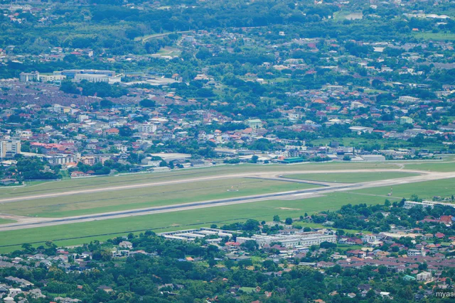 Chiang Mai International Airport runway seen against the city and surrounding hills