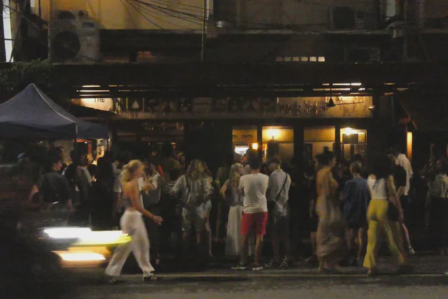 Crowd gathering around food stalls at a Chiang Mai night market