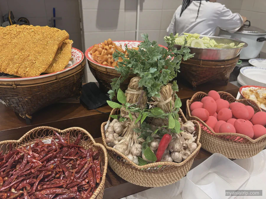 Herbs, chilies, vegetables and rice arranged in baskets for Thai cooking