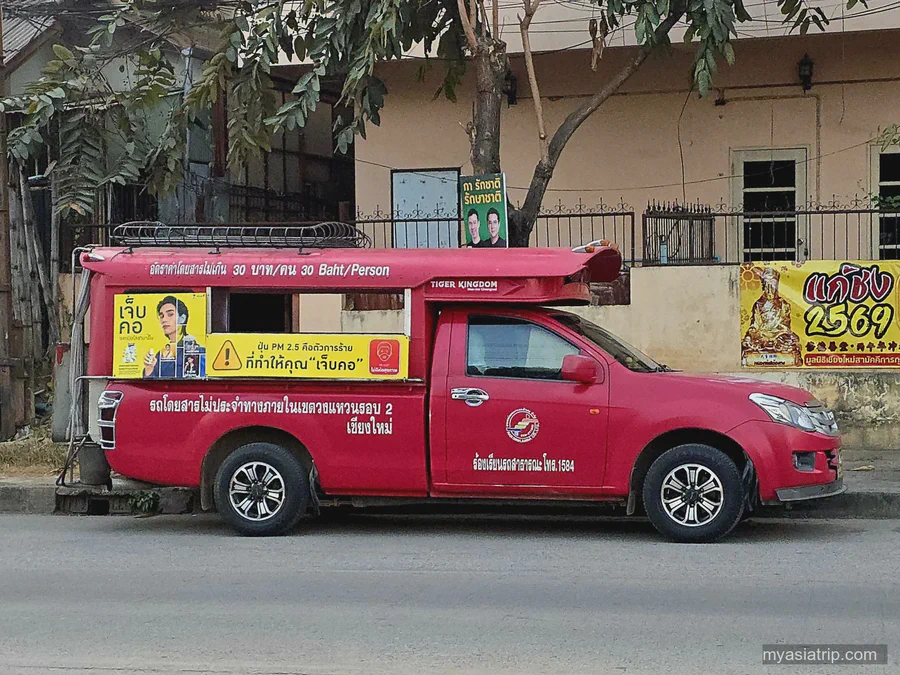 Red songthaew shared taxi driving through Chiang Mai