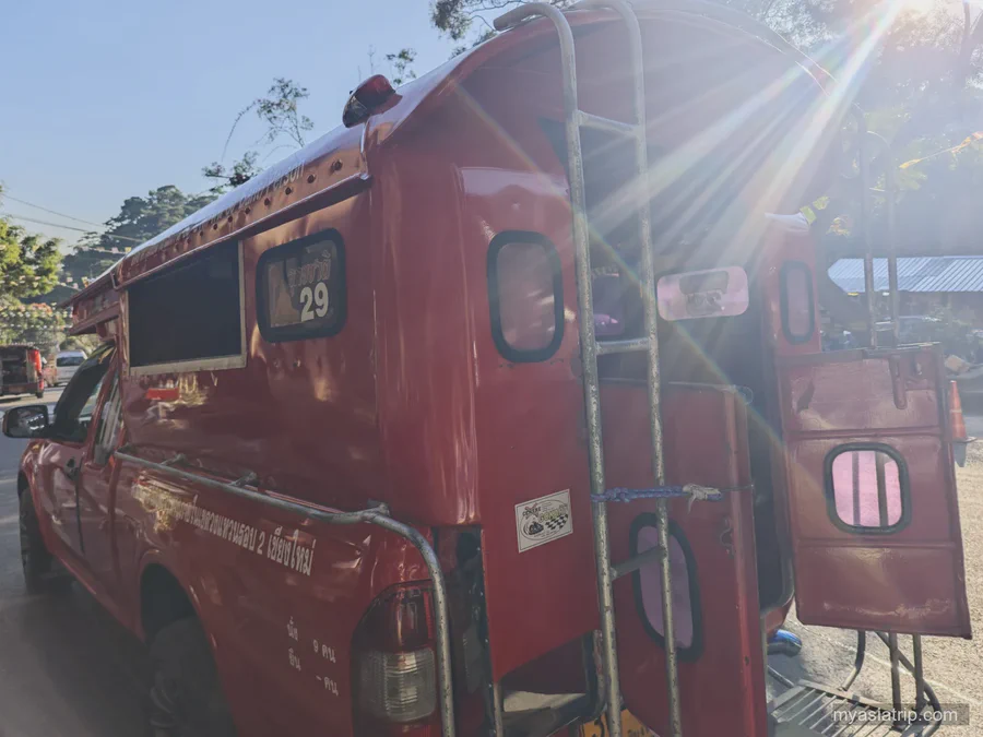 Open rear entrance of a red Chiang Mai songthaew