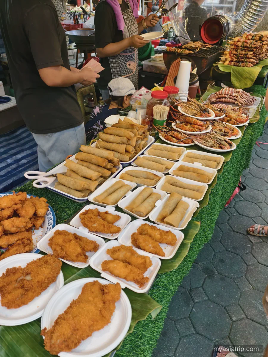 Prepared dishes lined up at a Chiang Mai food market