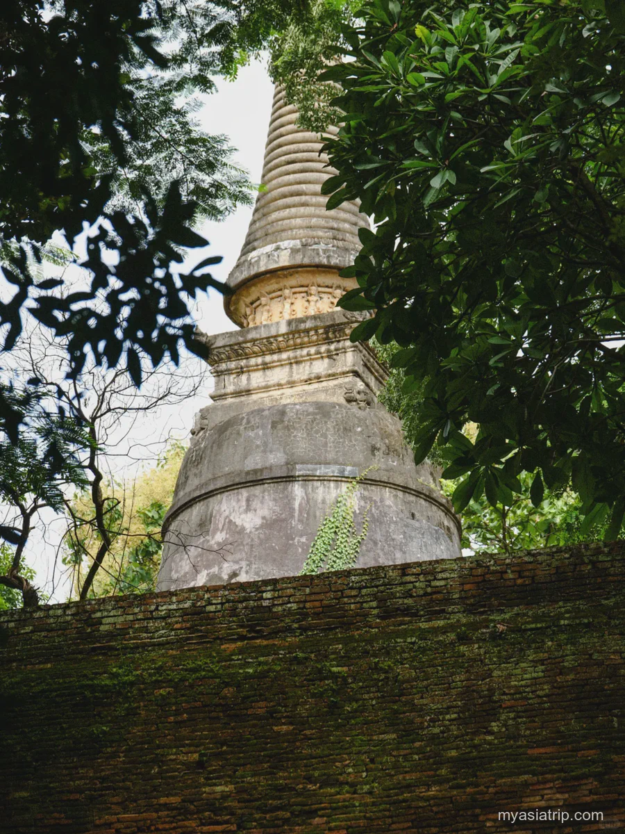 Weathered chedi rising above a mossy wall at Wat Umong in Chiang Mai