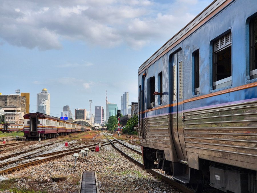 Passenger train traveling through an urban area in Thailand