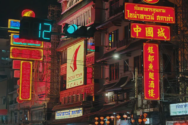Neon restaurant signs and Chinatown Scala buildings along Yaowarat Road at night